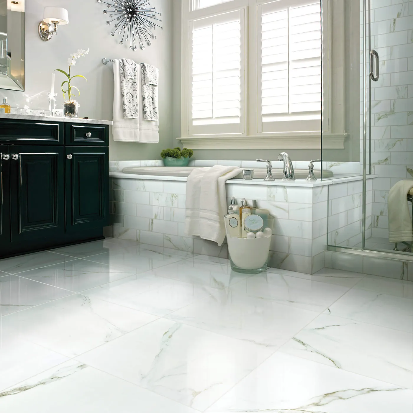 CASINO-POLISHED-CS37V-CASINO4X12-CS35V-CALACATTA-ORO-00121-V Shaw Floors Calacatta Oro polished white marble-look tile in a luxurious bathroom with a dark green vanity and a large soaking tub.