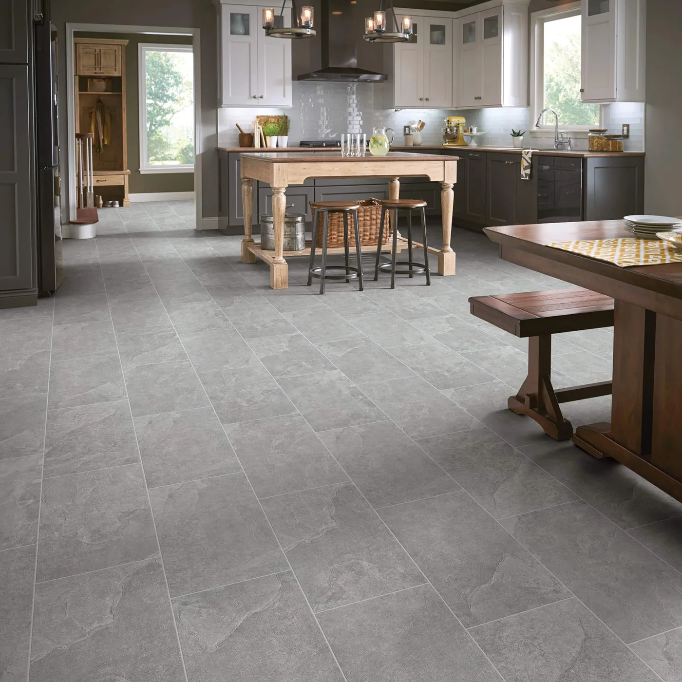 Crown-226TS-00550-Smoke-12x24-8U658-RM-H Shaw Floors Smoke gray large square tile in a kitchen with white and dark gray cabinets and a wooden island.